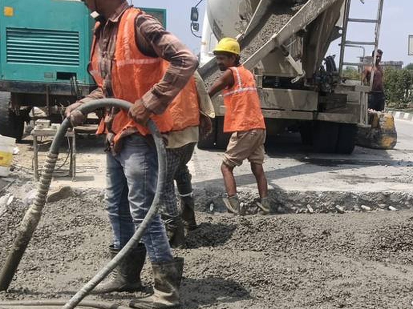 Workers compacting freshly poured concrete
